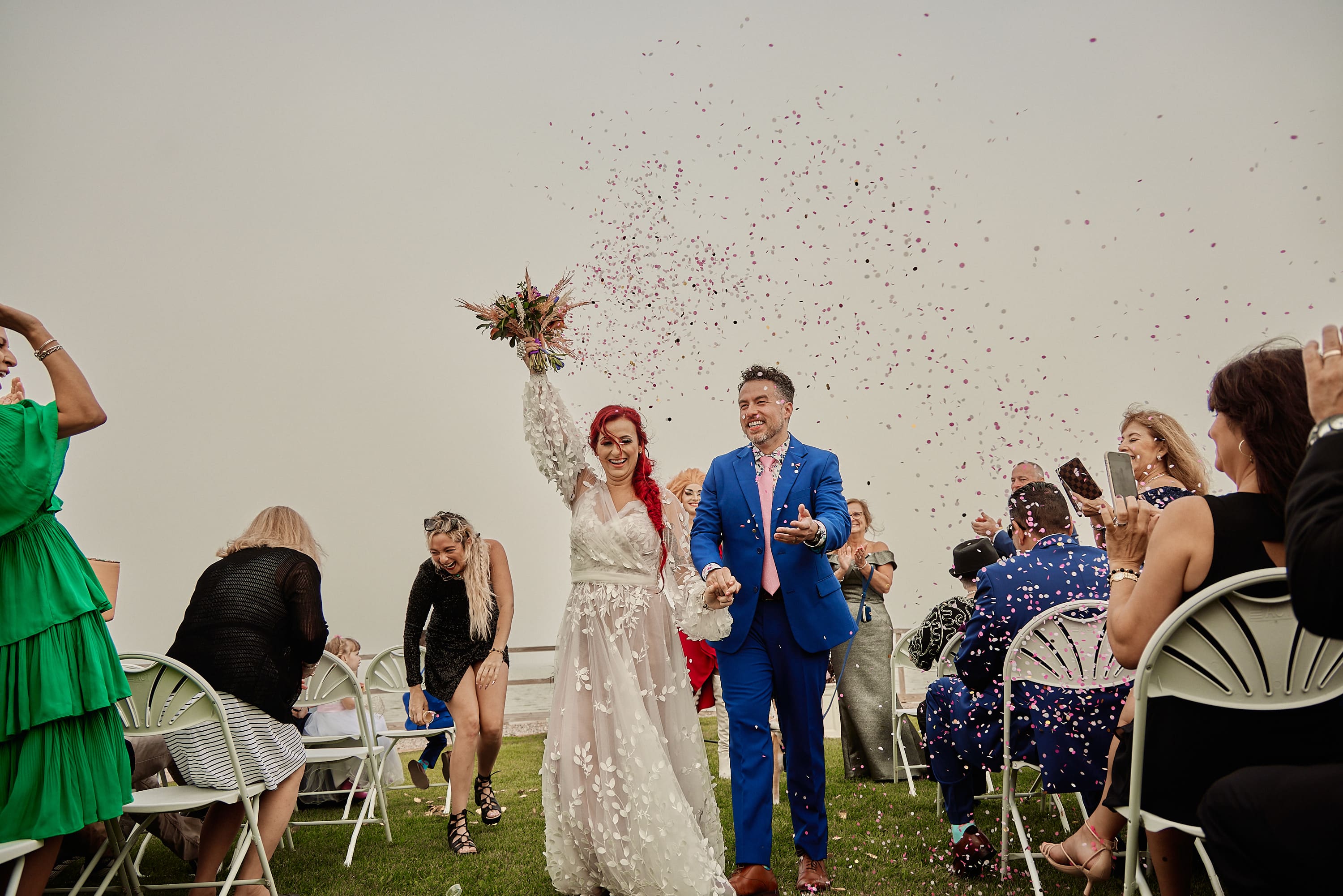 Candid photo of a wedding exit with red and white smoke bombs